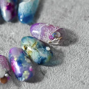 Vista macro di adesivi per unghie 3D con texture a onde e decorazioni di perle