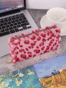 Pink leopard print plush pouch with gold zipper shown on a desk with a laptop