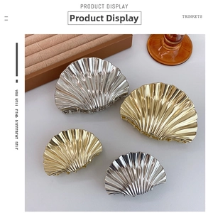 Macro shot of polished gold and silver metal seashell hair claws in two sizes