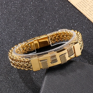 Close-up of golden punk style woven titanium steel bracelet for men on vintage paper background