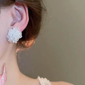 Nahaufnahme weißer Kristall-Blumenohrstecker für einen eleganten, modischen Look