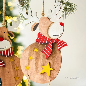 Wooden Christmas reindeer ornament with red scarf and star hanging on festive pine tree