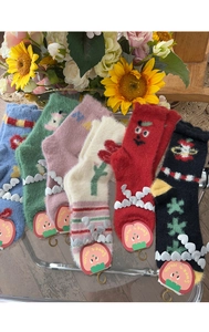 Close-up of five pairs colorful plush winter socks with cute cartoon patterns on tray