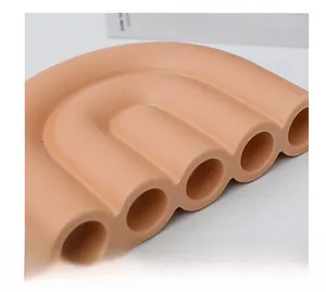 Macro detail van de oranjeroze keramische vaas met matte textuur en uniek multi-gat ontwerp