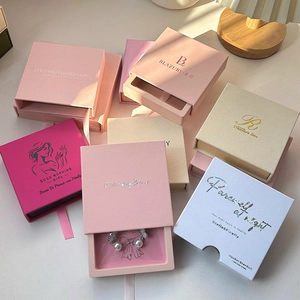 Cajas de joyería tipo cajón en varios colores con logo dorado y tirador de cinta