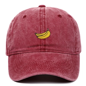 Close-up of a burgundy washed denim baseball cap with yellow banana embroidery detail