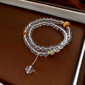 Detail of double-layer beaded bracelet with clear crystals and yellow tiger eye beads