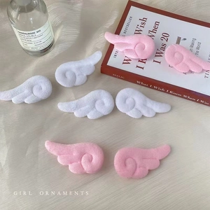 Makroaufnahme von Plüsch-Engelsflügeln in Rosa und Weiß für DIY-Haarschmuck