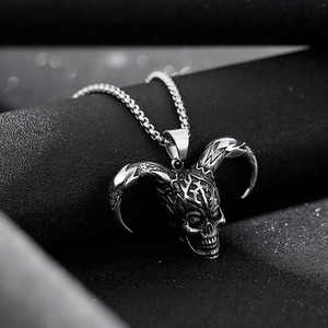 Close-up of a silver skull pendant with curved horns on a punk style steel necklace