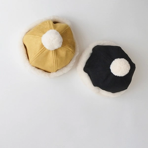 Detail of winter suede skull caps for kids with plush white pom-pom and faux fur trim