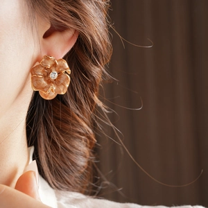 Détail de boucle d'oreille vintage fleur avec émail brun, cristal et perle pendante