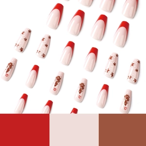 Christmas press-on nails with red French tips, star patterns, and coffin shape design