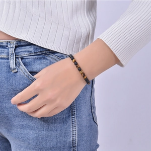 Détail du bracelet perles code Morse avec pierres mates et oeil de tigre sur le poignet