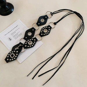 Detail of black leather waist belt with geometric studs and metal ring connectors