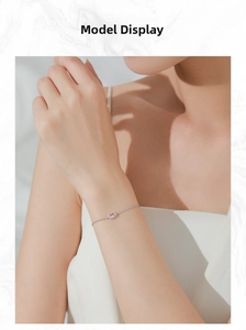 Nahaufnahme eines Silberarmbands mit einem rosa ovalen Edelstein und kleinen Kristallen