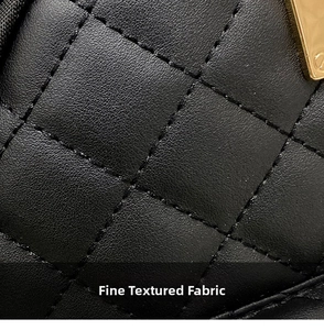 Close-up of black quilted leather backpack fabric with delicate litchi texture and gold hardware