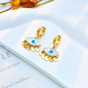 Golden Evil Eye hoop earrings with blue pupil and tassel discs on minimalist pedestal