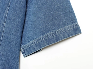 Detailansicht der Doppelnähte am Ärmelbündchen des mittelblauen Jeans-Kurzarmhemdes