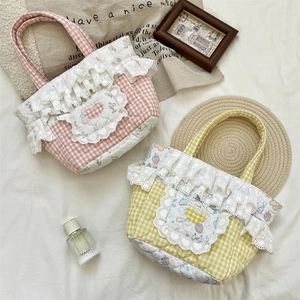 Detail of quilted tote bags featuring plaid patterns, lace trim, and floral strawberry motifs