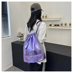 Back view of model wearing a metallic purple drawstring sports bag with bottom zipper compartment