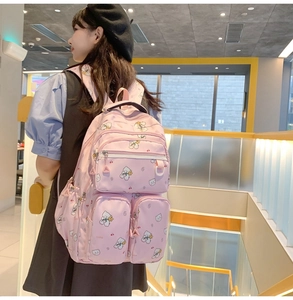 Pink Japanese backpack with white bear pattern shown from a side-view on a model