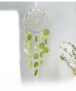Detail of bohemian shell wind chime dream catcher with green beads and white weave