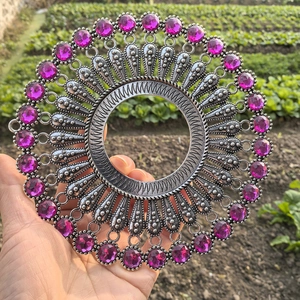 Detailed view of vintage silver metal wall decor with engraved patterns and purple gems