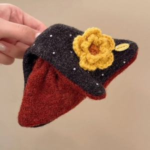 Détails de la texture tricotée d'une pince à cheveux triangle avec fleur en laine
