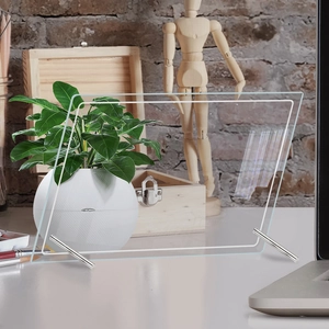 Detail of clear acrylic weekly planner board with metal support stands on a desk