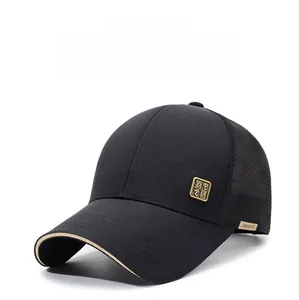 Detail of black breathable mesh baseball cap with golden square metal logo emblem