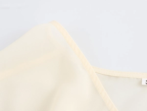 Dettaglio delle cuciture delle spalle e trama in chiffon dell'abito in pizzo beige