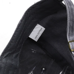 Detail of 100% cotton label and brass adjustment buckle on washed vintage baseball cap