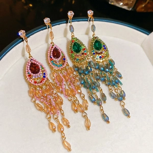 Detail of bohemian water drop tassel earrings with sparkling crystals in a jewelry dish