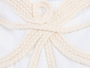 Close-up of white woven rope straps and textured floral knot detailing on the dress