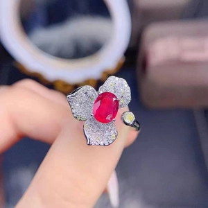 Detailed shot of a floral ring with a red oval gemstone and pavé-set petal accents