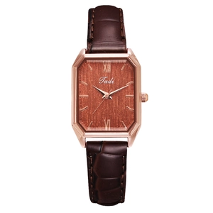 Detail of vintage square quartz watch with brown leather strap and rose gold case