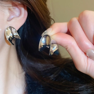Detailed view of silver liquid metal C-shaped earrings with irregular flowing texture