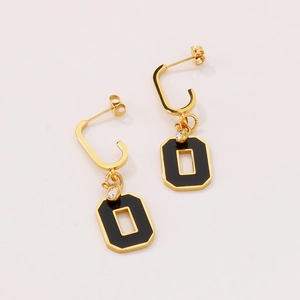 Detail of geometric black enamel gold earrings with small sparkling zircon accents
