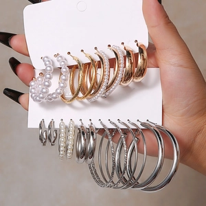 Detailansicht eines Ohrring-Sets in Gold und Silber mit Perlen und gedrehten Creolen