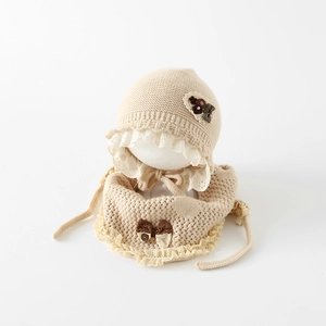 Détail de l'ensemble bébé en tricot avec bordure en dentelle et fleurs en tissu élégantes