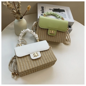 Detail view of woven straw box bags with cloud-shaped pleated handles and metal lock