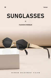 Detail of geometric hexagonal sunglasses with gold metal frame and dark grey lenses