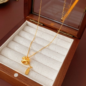 Detailed macro of gold plated necklace with rocking horse and Ping An lucky charm tag