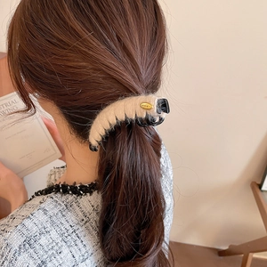 Détail de la pince à cheveux beige en acrylique peluche avec accent doré chic