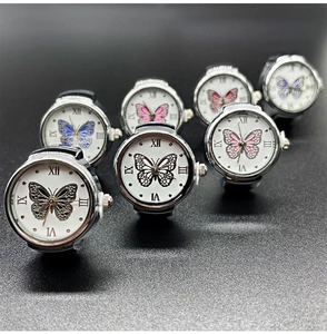 Detailed view of silver ring watches with mother of pearl dials and butterfly motifs