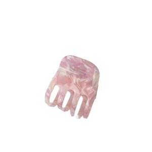 Pince à cheveux en acétate marbré rose avec inscription Barrette la France sur blanc