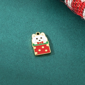 Close-up of golden enamel cat pendant inside red gift box charm for Christmas DIY