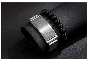 Detail of stainless steel bracelet with Spanish Lord's Prayer engraving and black beads