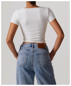 Rear view of a white V-neck breathable yoga t-shirt paired with blue denim jeans