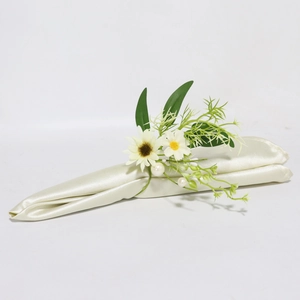 Dettaglio portatovaglioli con margherite bianche foglie verdi e perle decorative